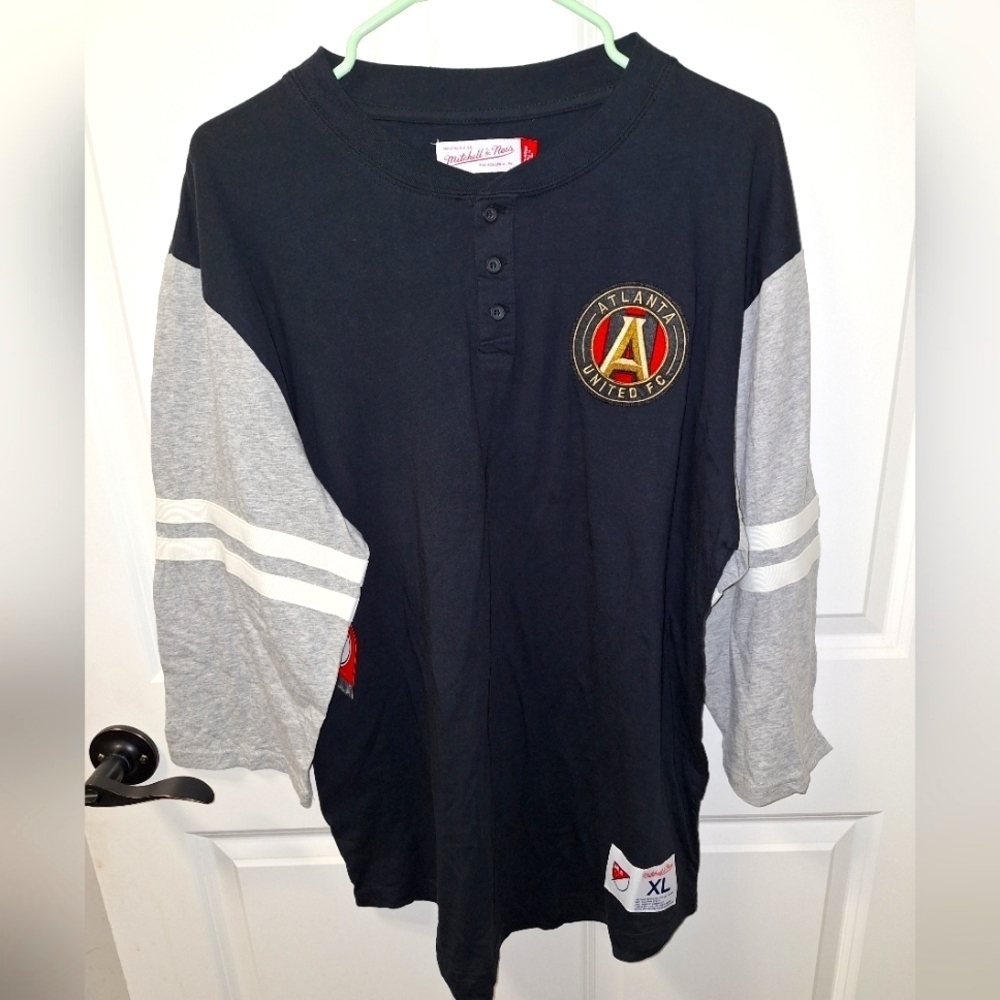 A Mitchell and Ness official MLS Atlanta United 3/4 sleeve Henley shirt in a XL.